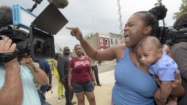 Massieka Holness, with her four-month-old son Tavon, reacts after prosecutors dropped all charges against police in Baltimore.