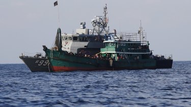 A migrants boat is seen tethered to a Thai navy vessel in waters near Koh Lipe island on Thursday. A boat crammed with migrants was towed out to sea by the Thai navy and then held up by Malaysian vessels on Saturday. 
