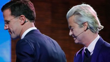 Right-wing populist leader Geert Wilders and Dutch Prime Minister Mark Rutte, left, leave the stage after a national televised debate.