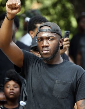 Devin Cousin of Florence, Mississippi raises his fist as he and about 200 mainly young marchers protest on Friday.