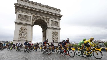 The peloton on the slippery cobbles of the Champs-Elysees during the neutralised final 10 laps of the Tour de France.
