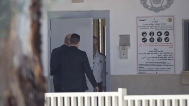 Ehud Olmert, left, enters prison to begin his sentence in the central Israeli town of Ramle.