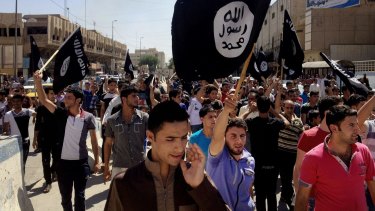 Demonstrators chant pro-Islamic State slogans as they carry the group's flags in front of the provincial government headquarters in Mosul.