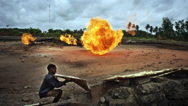 A child uses a pipeline flare to cook in Nigeria's Niger Delta.