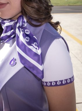 The uniform includes a purple scarf that can be worn as a hair, neck or pocket accessory.