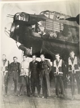 Pilot Frank Mouritz (centre, in the darkest uniform) of Bomber Command in front of Lancaster Mickey the Moocher.