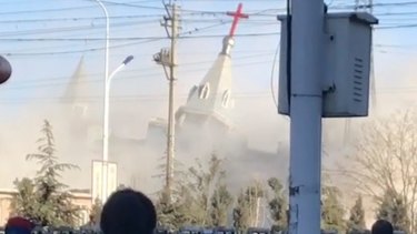 People watch the demolition of the Golden Lampstand Church in Linfen. Activists says the church had clashed with the government. 