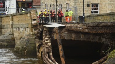 Emergency services check the collapsed bridge in Tadcaster, northern England, on Wednesday. Another storm was expected to hit many of the flood-affected areas of Britain the same day.