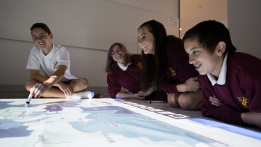Students from Campbelltown Performing Arts School, (L-R) Levi Crossman, Bethany Lewis, Bronte Galla-Laine, and Blake Fernandez, use the giant floor whiteboard at a media event to promote the classroom of the future at the Education Department in Eveleigh.