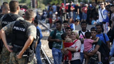 Migrants wait on Wednesday to board a train headed for Serbia, at the railway station in the southern Macedonian town of Gevgelija.  