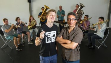 Beatboxer Chris Gale and director Felix Cross stand in front of Symphony Under the Star's brass ensemble.