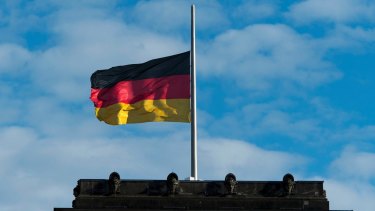 The German flag flies half mast on the Reichstags building in Berlin on Friday.