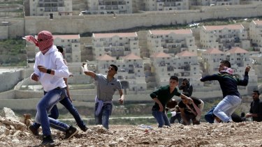 Palestinian youths throw stones at Israeli soldiers near the settlement of Beitar Illit in March, during protests to mark Land Day.