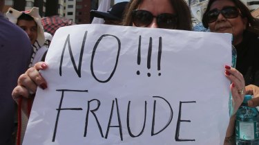 A supporter of Guillermo Lasso holds a sign reading "No to Fraud!" during Monday's protest in Quito.