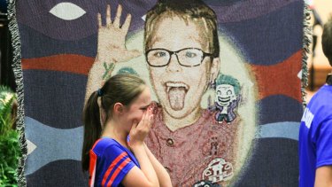 Starr Henderson, 12, of Belton, cries after seeing her nephew Jacob Hall during a wake service in the US.