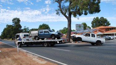 Vehicles linked to the roof-fixing scam are removed from Hazelmere's Banksia Tourist Park.