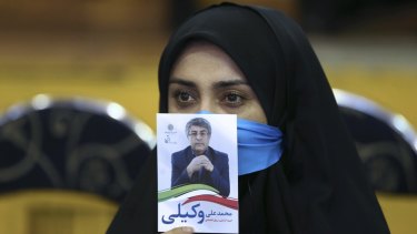 An Iranian woman holds a leaflet showing Mohammad Ali Vakili, a candidate in February 26 parliamentary elections, during a reformists' campaign rally in Tehran on Thursday.