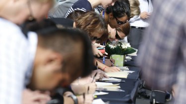 Outpouring: Hundreds are lining up to sign the condolence books at Martin Place.
