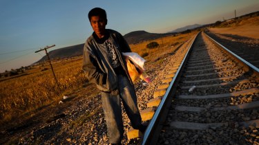 A Guatemalan asylum seeker waits on railroad tracks to climb on a cargo train bound for Mexico and the US. 