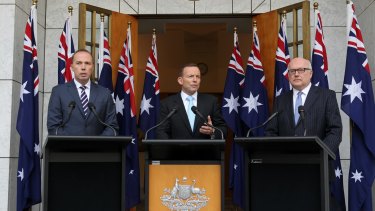 Tony Abbott appears with Peter Dutton and George Brandis in front of 10 flags at a press conference at which he criticised <i>Q&A</i>.