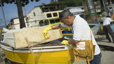 A health agent scoops water from a boat during an operation to eradicate the Aedes aegypti mosquito in Niteroi, Brazil, on Tuesday.
