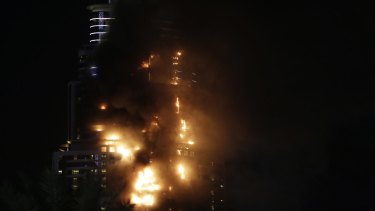 Smoke and flames pour from a residential building, which contains the Address Downtown Hotel, in Dubai.