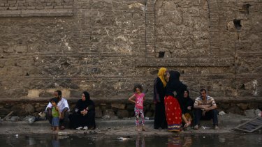 Egyptian families sit along a flooded street after their apartments were damaged in the blast.
