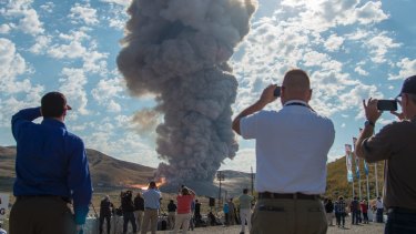 Spectators watch the second and final qualification motor test for the Space Launch System's booster.