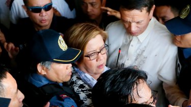 Philippine opposition Senator Leila de Lima, center, is escorted to her detention on Friday, a day after a warrant for her arrest was issued.