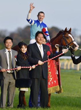 Top of the world: Hugh Bowman celebrates winning the Japan Cup on Cheval Grand. 