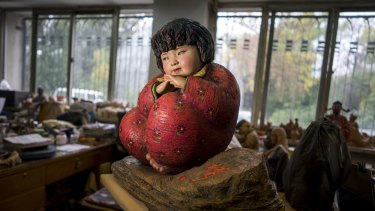 A giant traditional clay figurine of a chubby peasant girl in a red smock, at the centre of the Chinese government's "China Dream" campaign, in a studio in Tianjin.