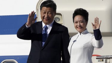 Xi Jinping and his wife Peng Liyuan wave upon landing in Washington state on Tuesday.