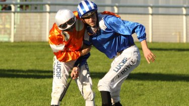 Jockey James Doyle is helped up by fellow jockey Blake Shinn after his horse Almoonqith fell..