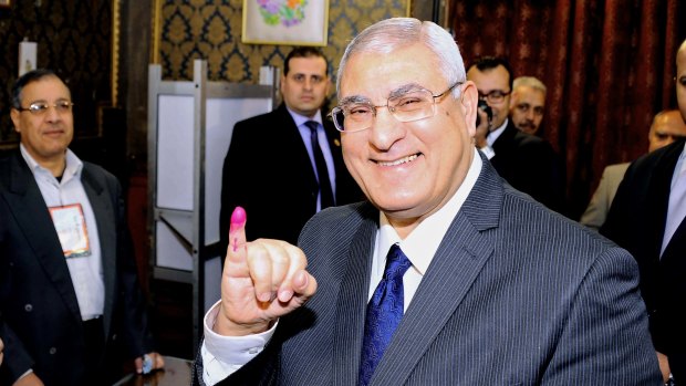 Interim President Adly Mansour shows his ink-stained finger after casting his vote at a polling station in Cairo, Egypt.