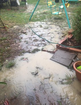 Floodwaters washing from a cleared Mr Fluffy block in Goulburn Street, Macquarie, against the house and into the yard of neighbours Greg and Melissa Wilson, who are worried about contamination.