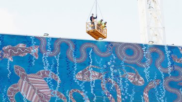 Staff in a 'man box' hung from a crane helped mount the artwork.