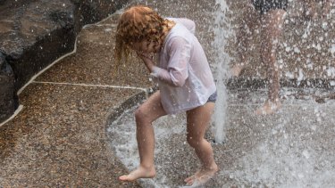Claudia White, 4, cools off at the Wild Play Garden in Centennial Park.