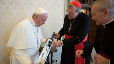 Pope Francis receives a cricket bat from Cardinal George Pell at the Vatican in 2015.