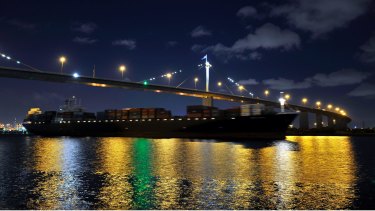 A container ship sails down the Yarra River under the West Gate Bridge after leaving the Port of Melbourne. 