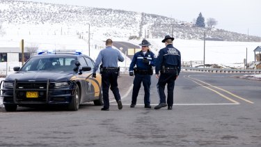 Oregon State Police man a roadblock at the intersection of highways 395 and 20 outside Burns, on Wednesday .