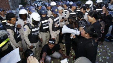 Police block human rights activists during  their candlelight vigil in Phnom Penh on Monday.