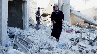 Residents inspect damage from what activists said were barrel bombs dropped by Syrian regime forces in the town of al-Hara, in Syria's southern Daraa province.  