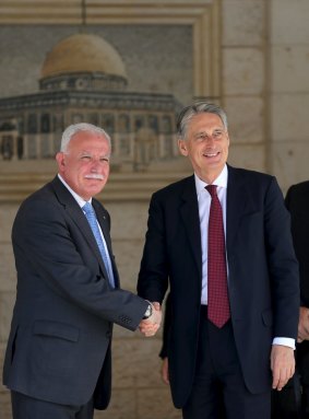 Philip Hammond shakes hands with Palestinian Foreign Minister Riyad al-Malki in the West Bank city of Ramallah on Thursday, in front of a mural of the Dome of the Rock, which is part of Israeli-occupied East Jerusalem.