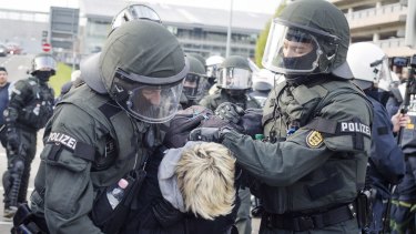 Police detain a leftist demonstrator near the site of the Alternative for Germany party convention.