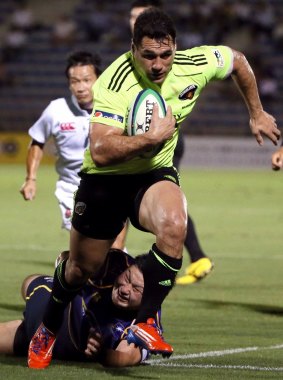 Lighter opponents: Smith playing for Suntory Sungoliath against NTT runs with the ball to score a try during the Japan Rugby Top League match in Tokyo last year.