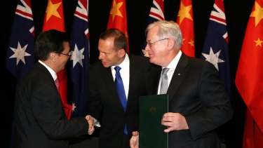 Prime Minister Tony Abbott and Minister for Trade Andrew Robb shake hands with China's Minister of Commerce, Gao Hucheng, during the China-Australia FTA signing ceremony in Canberra last week.