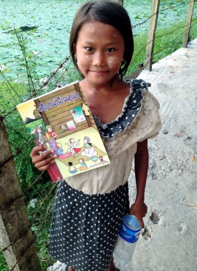 A girl from the island of Seikkyi, one of Myanmar's poorest neighbourhoods holds the book "Where women have no doctor". Photo: Daisy Dumas.