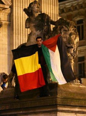 A man waves a Belgian and a Palestinian flag as a mark of solidarity at the Place de la Bourse on Tuesday. 