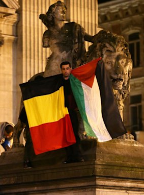 A man waves a Belgian and a Palestinian flag as a mark of solidarity at the Place de la Bourse in Brussels on Tuesday. 