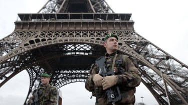 French soldiers patrol in front of the Eiffel Tower on Wednesday after terrorists killed at least 12 people in Paris. 